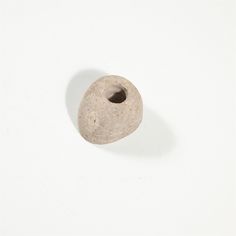 a small stone object sitting on top of a white surface