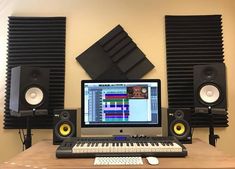 a desktop computer sitting on top of a wooden desk next to speakers and a keyboard