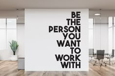 an office with a large wall decal that says be the person you want to work with