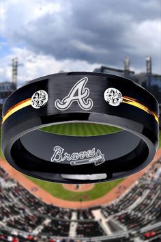 the atlanta braves ring is on display in front of a baseball field with clouds overhead