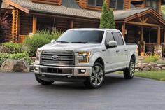 a white truck parked in front of a log cabin