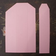 two pieces of pink paper cut out to look like they are facing each other