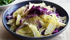 a blue bowl filled with cabbage and other vegetables