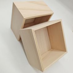 two wooden boxes sitting side by side on a white surface