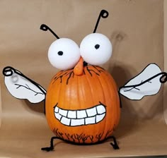 a pumpkin with googly eyes and wings on it