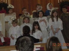 a group of children dressed in white standing next to each other at a wedding ceremony