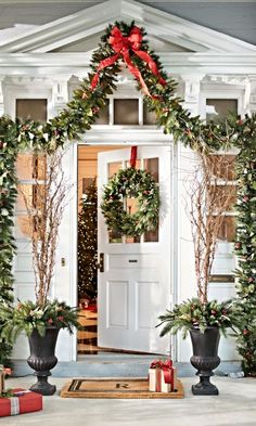 christmas wreaths are hanging on the front door