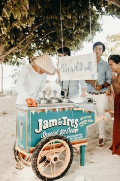 a group of people standing around a food cart with a sign that says james's special ice cream