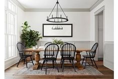 the dining room table is surrounded by black chairs and an oval chandelier above it