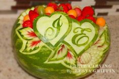 a carved watermelon with fruit in the shape of hearts and numbers on it