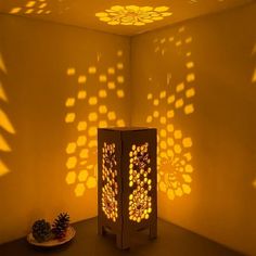 a table with a pine cone on it in front of a light box that is projected onto the wall