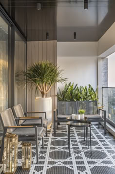 a balcony with chairs, tables and potted plants