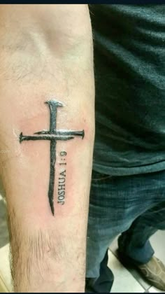 a man with a cross tattoo on his arm