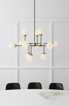 a white table with black chairs and a chandelier