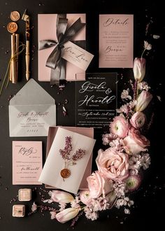 the wedding stationery is laid out on top of each other, including pink flowers