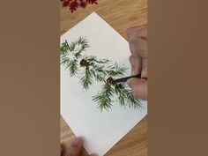 someone is using scissors to cut out pine cones on a piece of paper with watercolor pencils