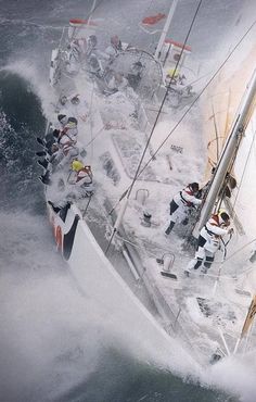 several people on the side of a boat in the water while it is snowing