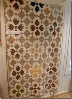 a quilt hanging on the side of a wall next to a door in a room