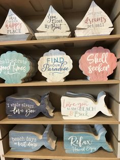 wooden signs on shelves in a store with sayings and phrases painted on the sides