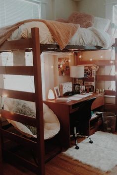 a bunk bed with a desk underneath it in a room that has wood floors and white walls