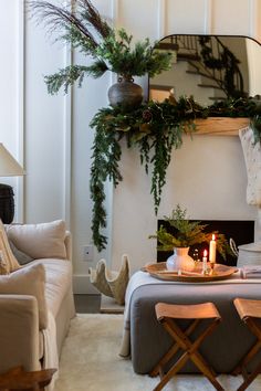 a living room filled with furniture and a fire place covered in greenery next to a fireplace