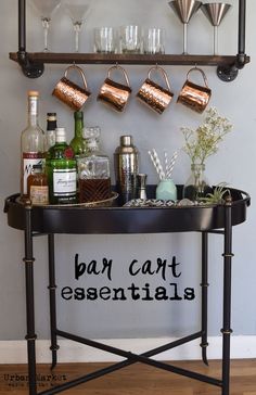 a black table topped with lots of bottles and glasses next to a wall mounted shelf