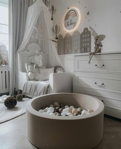 a bedroom with white furniture and lots of rocks in the bed area, including a round tub