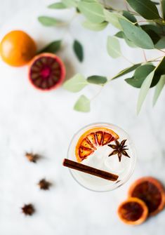 an overhead view of a drink with oranges and cinnamon sticks