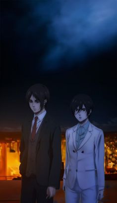 two young men standing next to each other in front of a dark sky at night