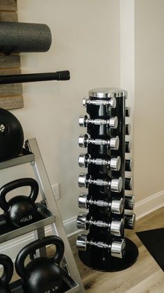 there is a stack of dumbbells in the corner next to a gym equipment rack