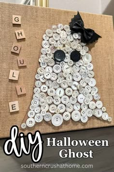 a diy halloween ghost made out of buttons on a burlocked canvas