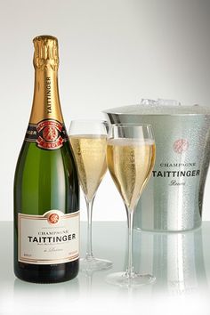 two champagne glasses and a bottle of tattinger are sitting next to each other