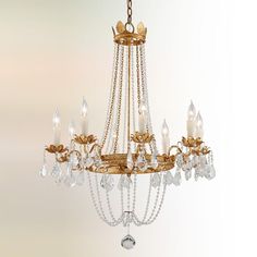 a gold chandelier with crystal drops hanging from it's center and sides