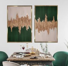 two paintings hanging on the wall above a dining room table with green chairs and place settings