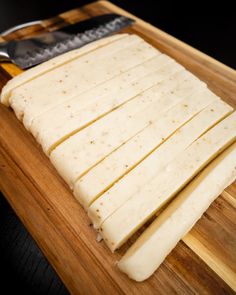 the cheese is cut up and ready to be cooked on the cutting board with a knife