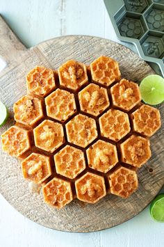 a wooden cutting board topped with honeycombs and lime slices