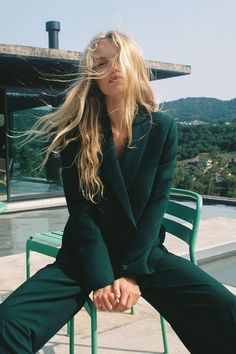 a woman sitting on top of a green chair