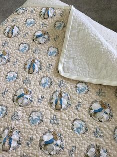 an unmade bed with blue and white designs on it