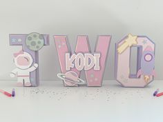 the word w is made up of wooden letters with stars around it and a cartoon character next to it