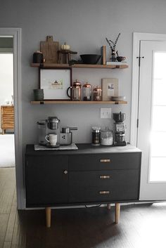 a kitchen area with shelves, pots and pans