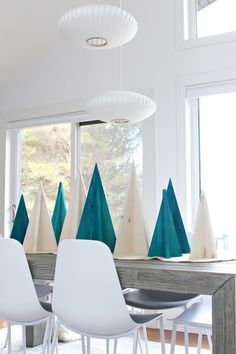 a dining room table with white chairs and blue vases