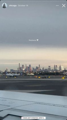 an airplane is on the tarmac at dusk with city lights in the back ground