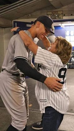 two baseball players hugging each other in the dugout