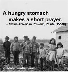 a group of children standing next to each other in front of a small house with a quote on it