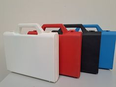 four different colored plastic containers sitting on top of a white table next to each other