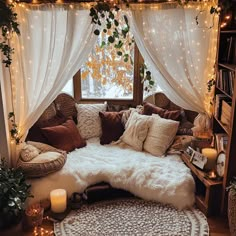 a living room filled with lots of furniture next to a window covered in white curtains