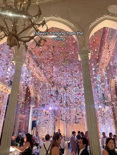 people are standing in the middle of a room with chandeliers hanging from the ceiling