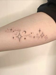 a woman's arm with stars and crescents on it, in black ink