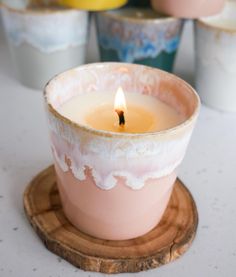 a lit candle sitting on top of a wooden coaster