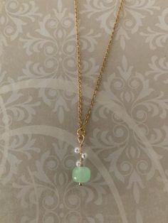 "Lovely, sweet and dainty gold tone, hetian jade bead and simulated seed pearls necklace, hetian jade necklace, mint green necklace, mint necklace, hetian jade pendant, green and pearl, green Pendant measures 7/8\" L X 5/16\" W and is on an 18\" chain." Dainty Gold Jade Necklace, Green Jade Necklaces For Weddings, Green Pearl Chain Jewelry As A Gift, Green Pearl Drop Necklace Gift, Green Pearl Necklaces With Pearl Pendant, Green Pearl Drop Necklace For Gift, Green Pearl Necklace As A Gift, Delicate Green Charm Necklace For Gift, Delicate Green Charm Necklace As Gift